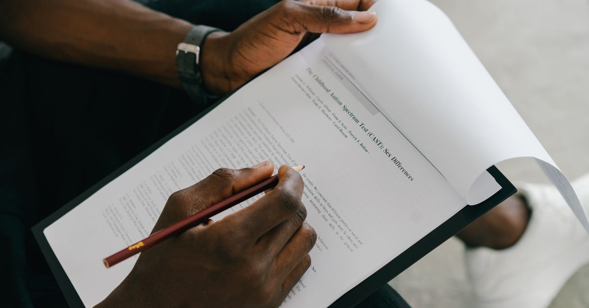 Close-up of a person writing on a psychological assessment form with a pencil.