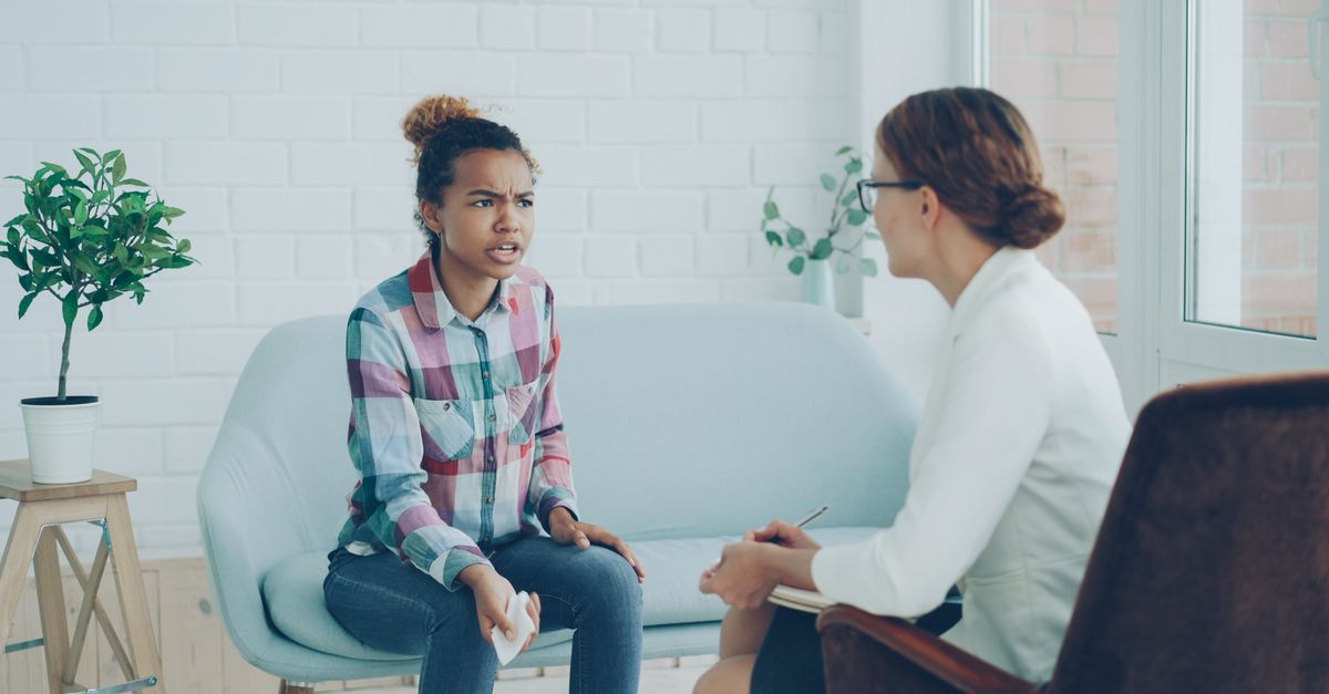 Therapist and patient in conversation during a counseling session indoors.