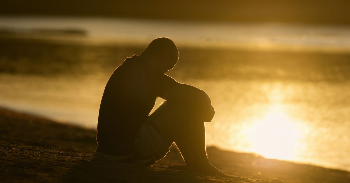 Silhouette of a person meditating by the water as the sun rises at Cove Island Park in Stamford, Connecticut.