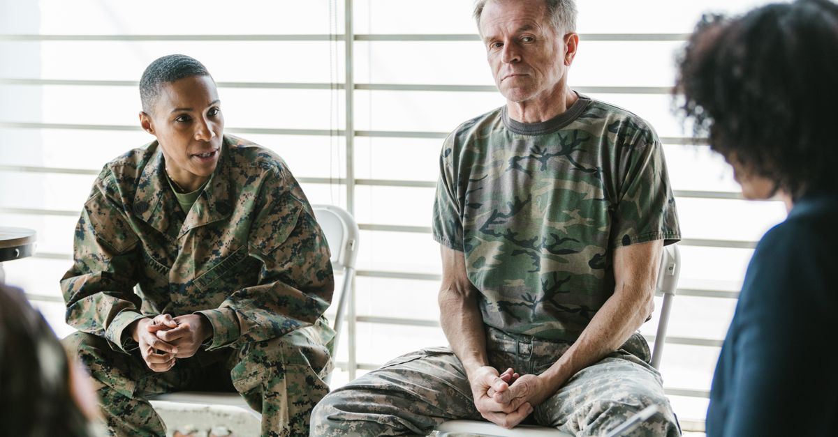 Military personnel discuss mental health in a supportive group therapy session.