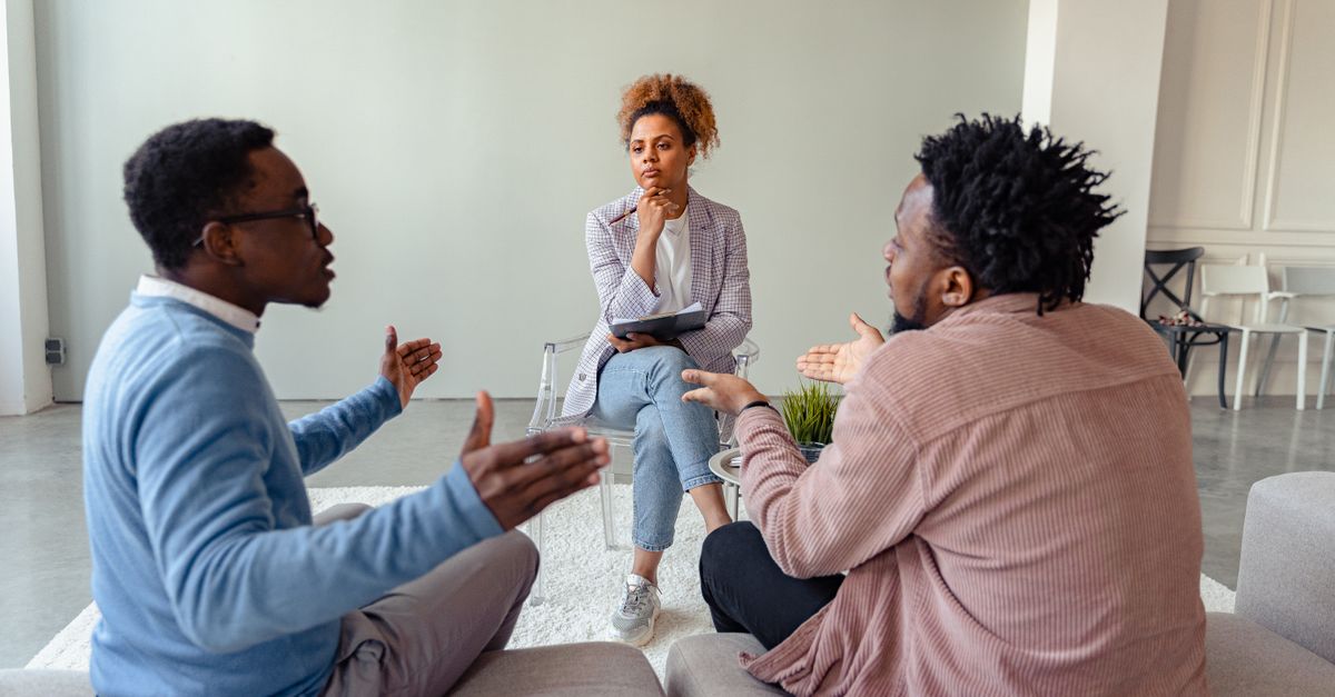 A therapy session featuring a diverse group discussing issues with a mental health professional.