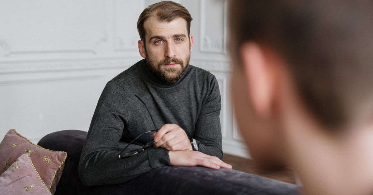 A therapist engages in a focused psychotherapy session with a patient in an indoor setting.