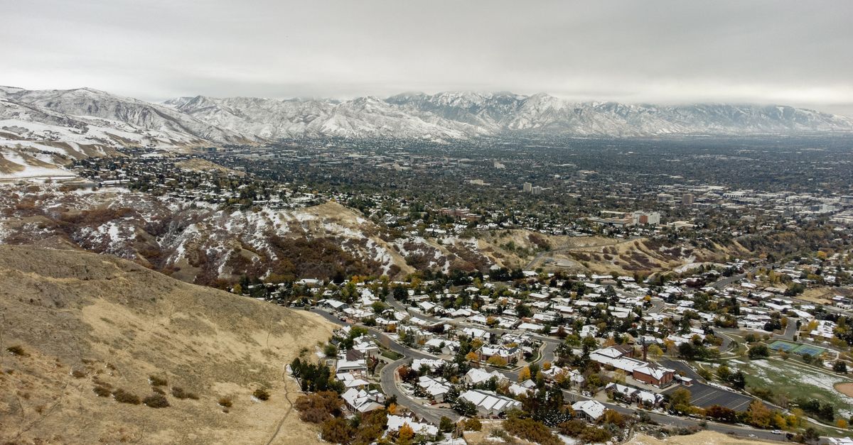 A stunning aerial perspective of snow-dusted Salt Lake City, highlighting its winter landscape and surrounding mountains.